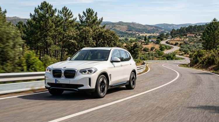 Ein BMW iX3 der Neuen Klasse fährt auf einer Landstraße durch portugiesische Hügellandschaft