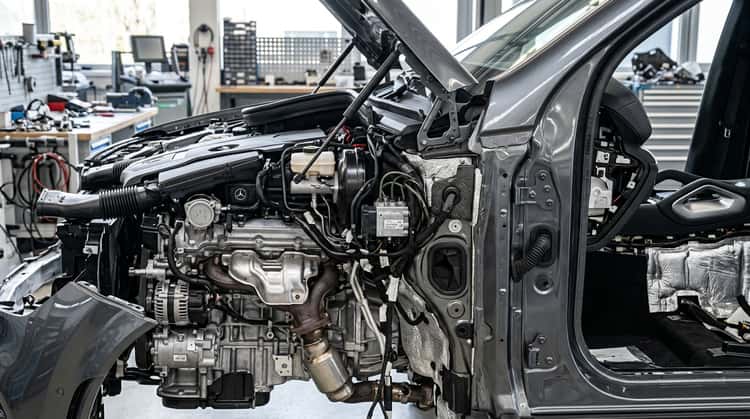 Nahaufnahme des Motorraum-Bereichs eines Mercedes-Benz GLE, wo das fehlerhafte Abschirmblech an der Kraftstoffleitung scheuern kann