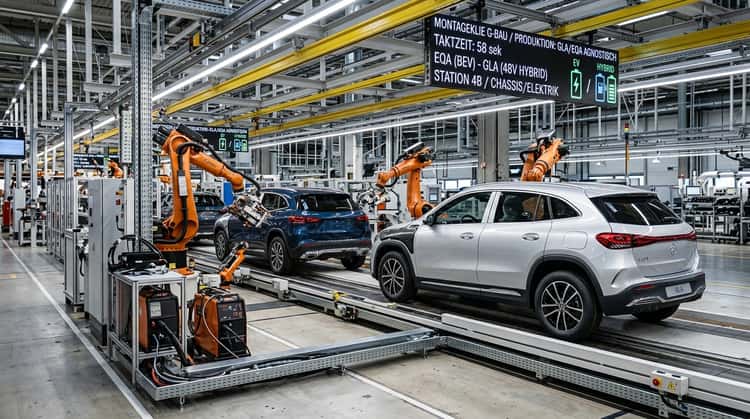 Moderne Automobilfabrik mit Fertigungslinie: Ein Mercedes-Benz GLA mit Elektroantrieb und ein 48V-Hybrid-Modell durchlaufen gemeinsam das Band an Roboterarmen vorbei.