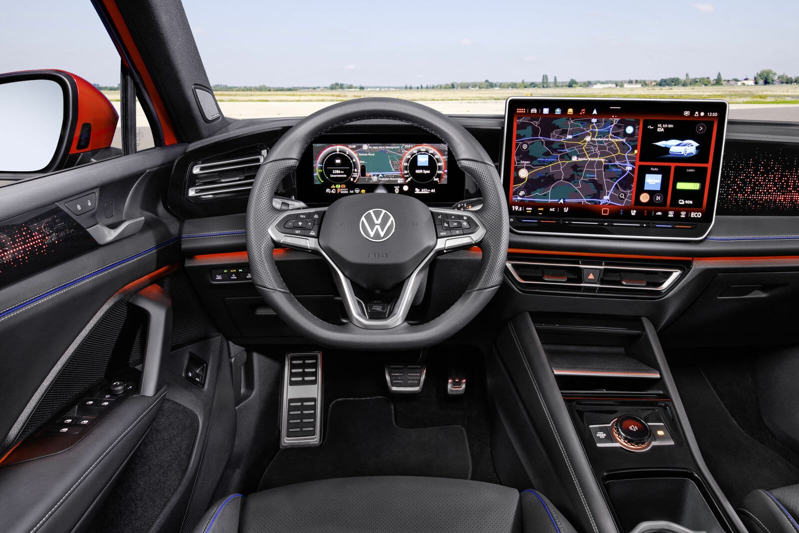 Blick ins Fahrzeug-Cockpit mit Lenkrad, digitalem Instrumentencluster und Infotainment-System